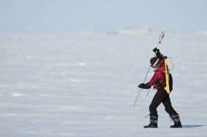 Researcher Melinda Webster uses a probe to measure snow depth and verify NASA airborne data. She is walking on sea ice near Barrow, Alaska in March 2012. Her backpack holds electronics that power the probe and record the data.  Chris Linder / Univ. of Washington