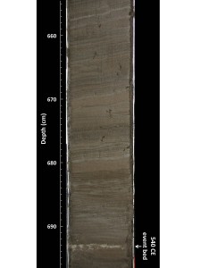 Photograph of a section of sediment core from Salt Pond. The light colored sand layer at 693 cm (22.7 feet) down the core provides evidence of an intense storm that occurred approximately in 540 CE (about 1,080 years before the first Europeans settle New England).  Credit: Jeffrey Donnelly, WHOI