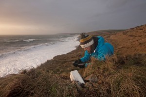 Claire Earlie, a PhD student at the School of Marine Science and Engineering at Plymouth University, uses a seismometer to measure cliff vibration caused by breaking waves on the shores of West Cornwall in the United Kingdom. Credit: Lloyd Russell/Plymouth University